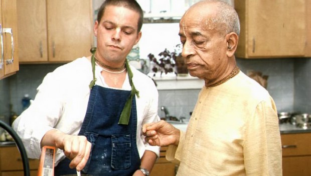 Srila Prabhupada watching a devotee cook in the kitchen